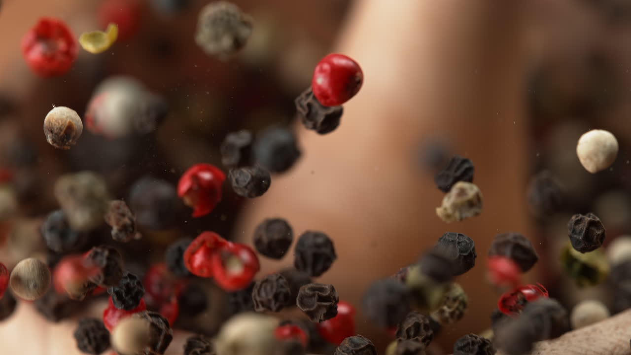 Wooden Mortar Filled With Colorful Peppercorn Blend Crushed With Pestle In Macro and Slow Motion