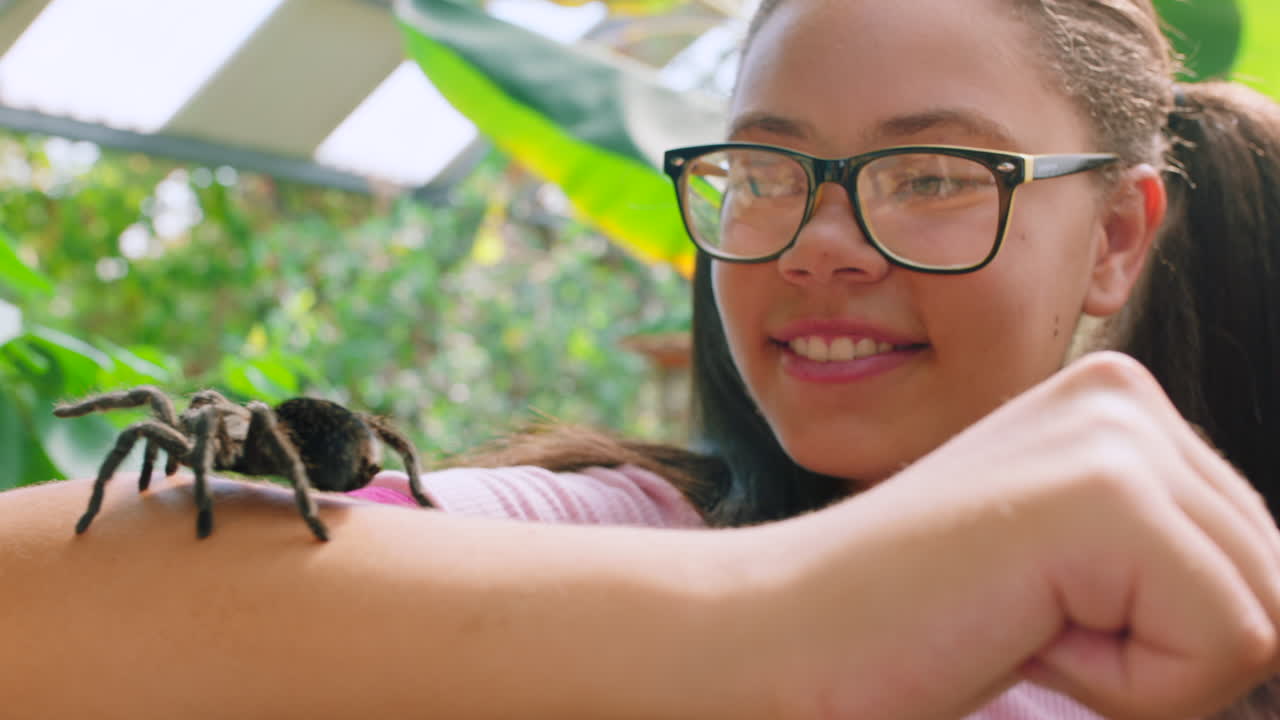 niña tomando una foto de araña en su brazo