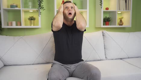 hombre deprimido y constreñido que tiene un ataque de pánico en casa.