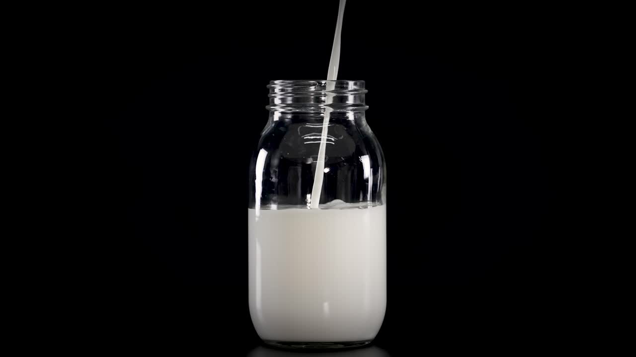 Milk being poured into jars with straws