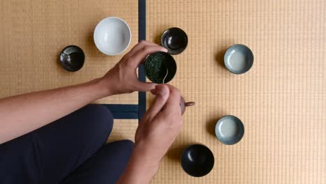 hombre realizando la ceremonia del té en tatami - plano medio