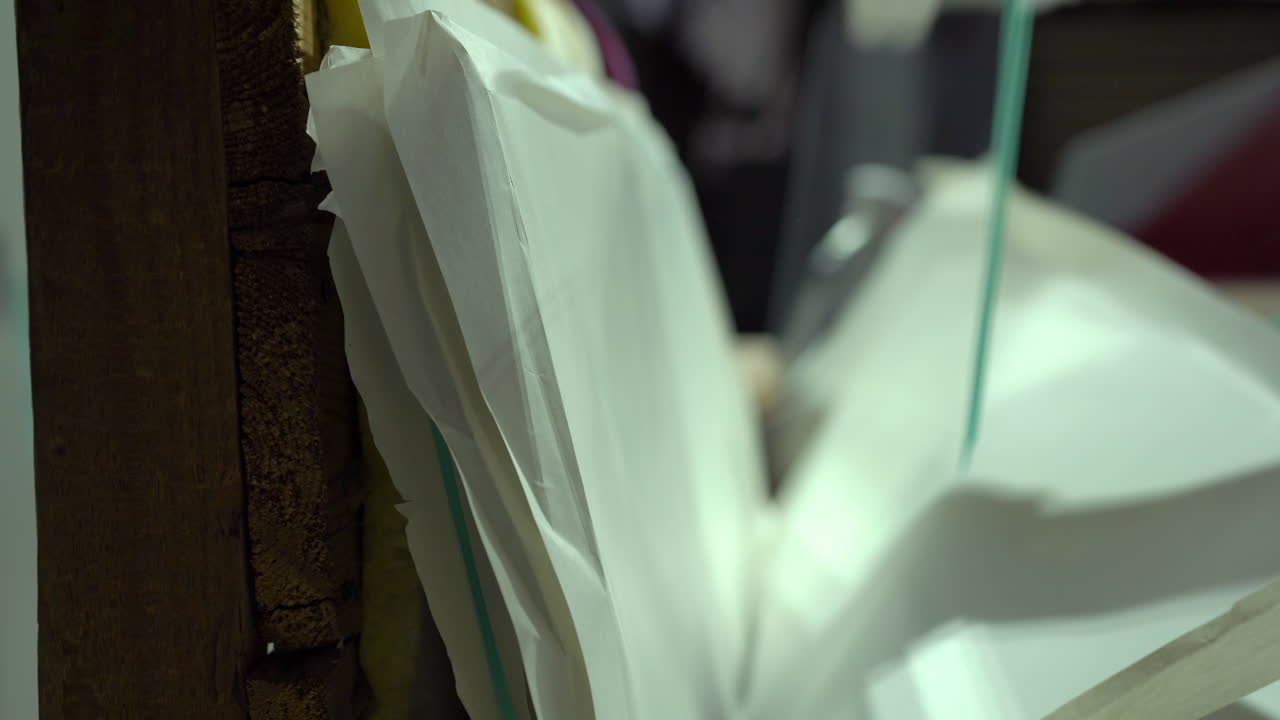 Worker unpacking glass panels stacked with paper sheets