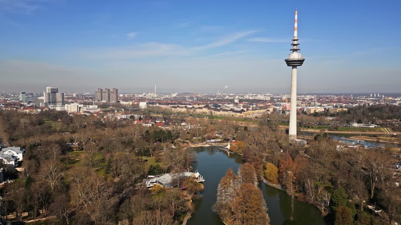 drone flight over Luisenpark in Mannheim with river Neckar and cityscape in background on a sunny day