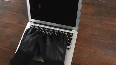manos de un ladrón usando una computadora portátil