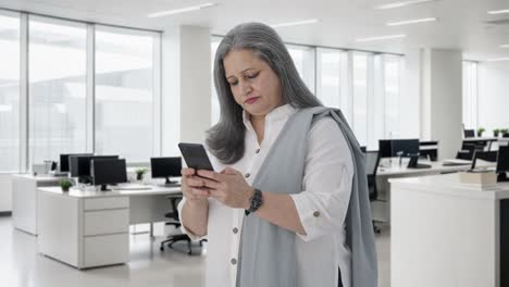 una mujer de negocios india hablando por teléfono.