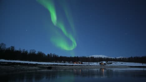 escena de invierno con cabaña de madera ozy y auroras boreales arriba en el paisaje del norte ártico de noruega, lapso de tiempo, bellas imágenes de la naturaleza