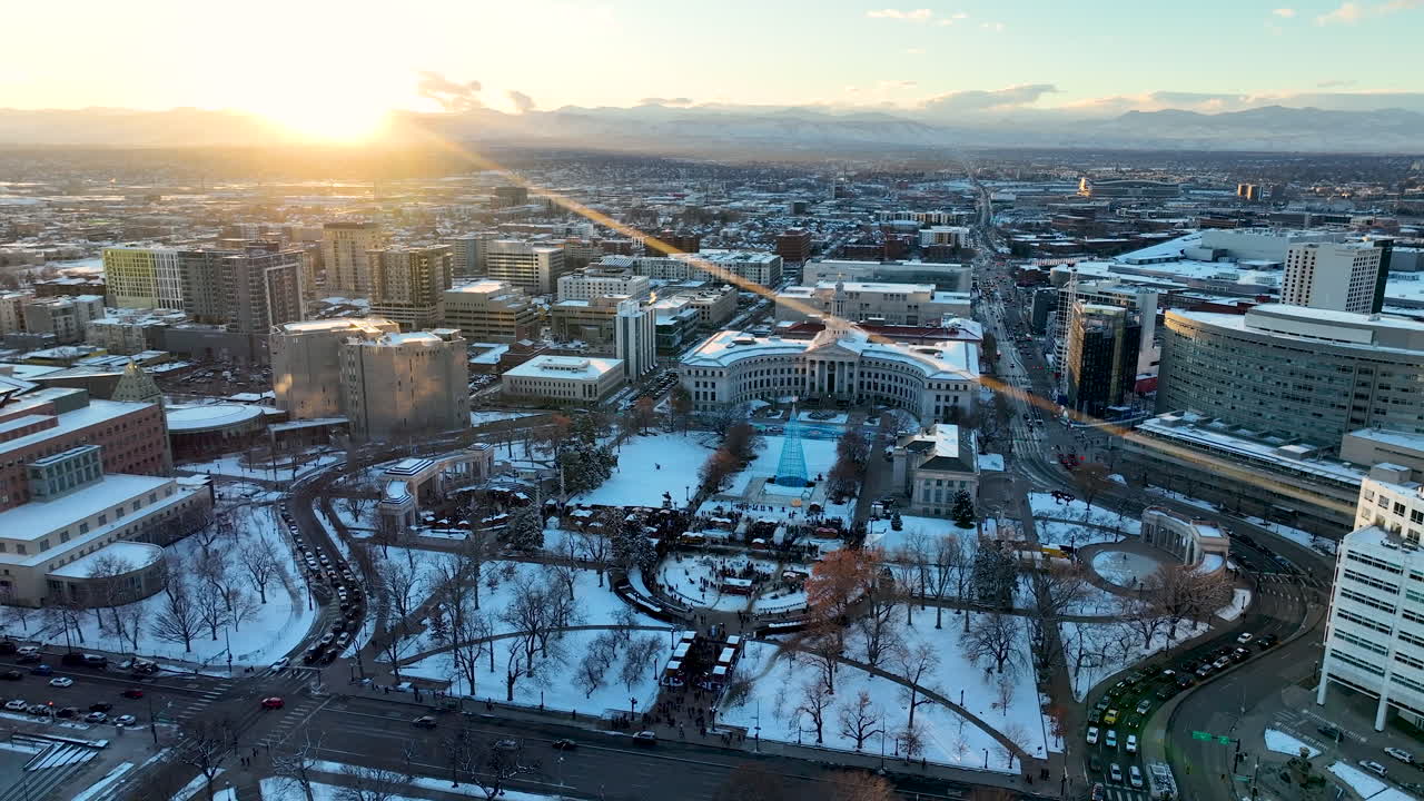 Drone al tramonto invernale sopra il Civic Center Park innevato durante il Christkindlmarket di Denver.