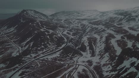 dunkle winterszene mit verschneiten bergstraßen islands - luftaufnahme