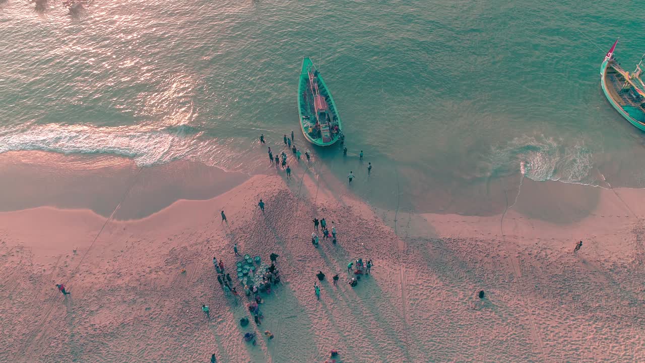 지역 어부들이 해가 뜨면 배에서 잡은 물고기를 해변으로 내리는 모습 (공중에서 볼 수 있는 사진, 인도네시아)