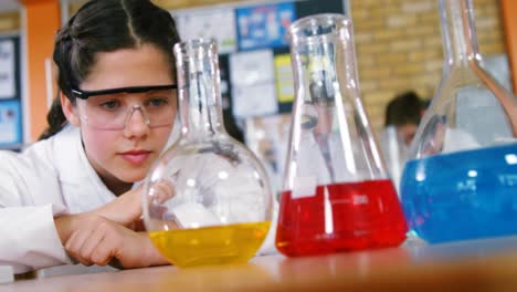 escolar observando productos químicos en el laboratorio