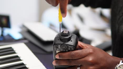 Man-closing-the-camera-flash-with-a-screwdriver