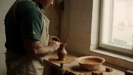 ceramista que fabrica productos de arcilla en la rueda de cerámica