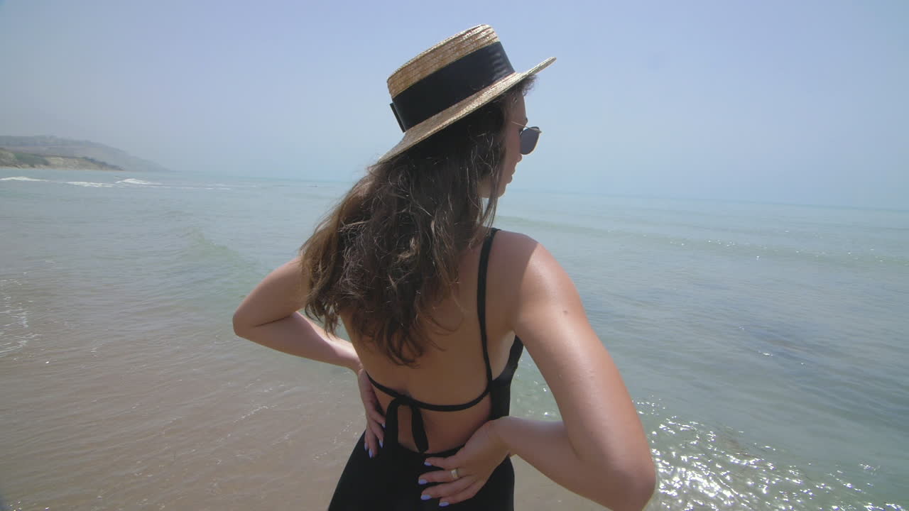 해변에서 모자와 수영복을 입은 여자