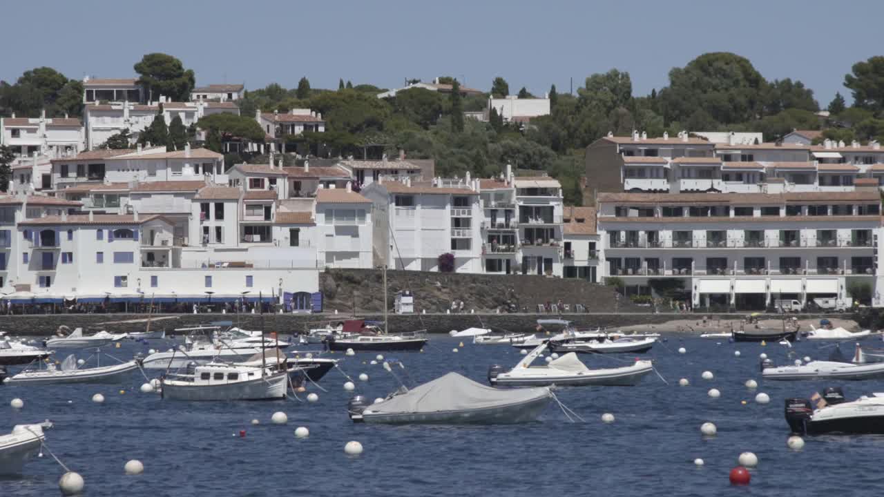 barcos estáticos en ciudad costera, casas blancas al fondo, costa brava, españa