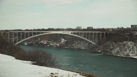 rainbow bridge by snowy niagara falls in winter, wide static view