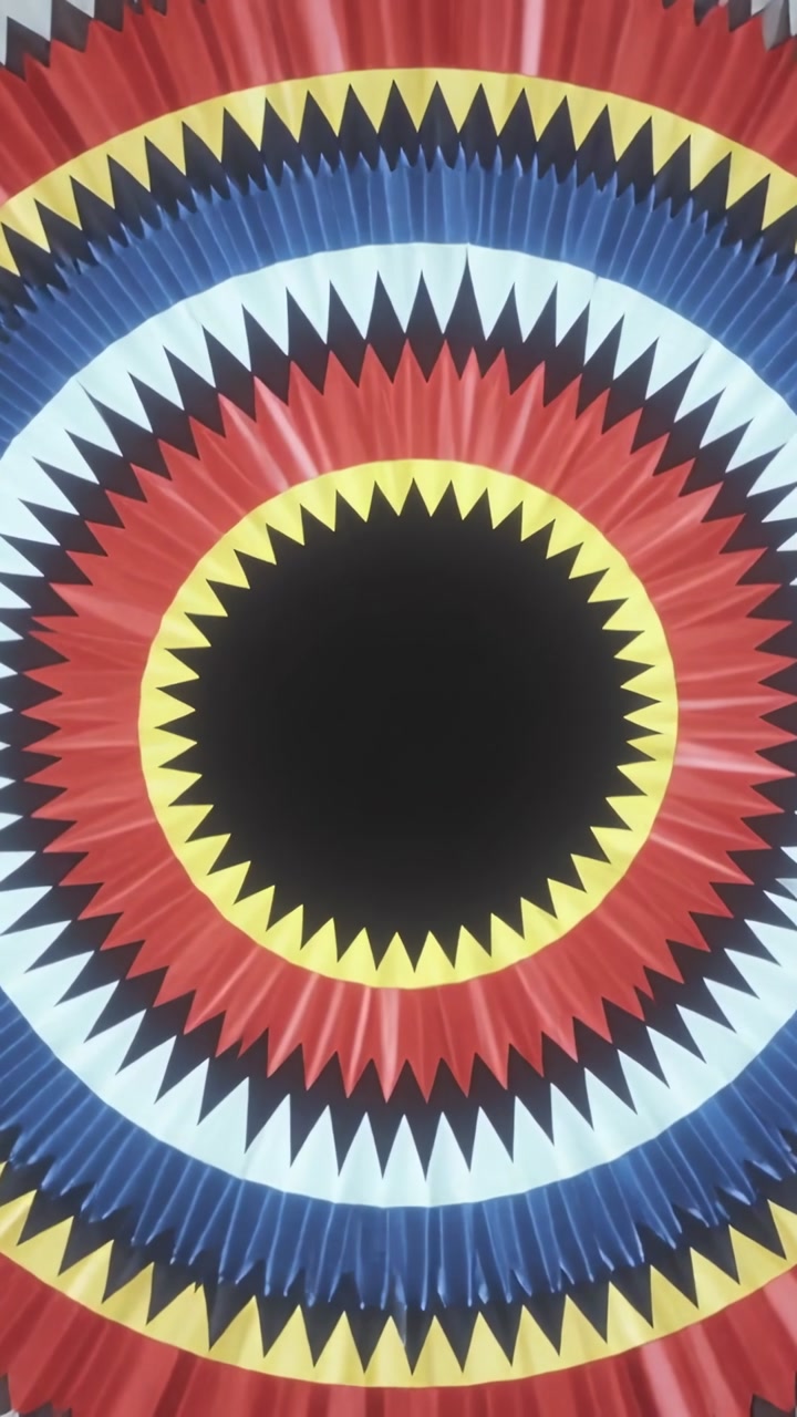 Vertical video: Tilting camera revealing pleated rosette with dark disc on wall to show color rings