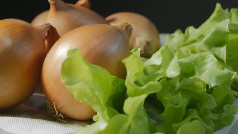 golden onions and green lettuce. the vegetables are spinning. close-up, looping video. eco products for healthy food