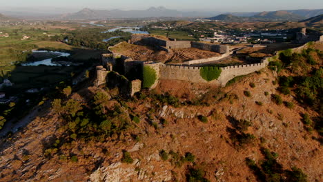 toma aérea cinematográfica al atardecer y alejándose del castillo shkoder de rozafa