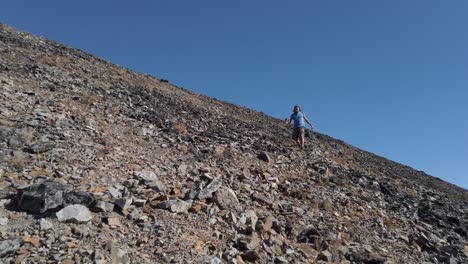 hiker fast pace descending down a rocky mountain trail low angle slow motion pan kananaskis alberta canada