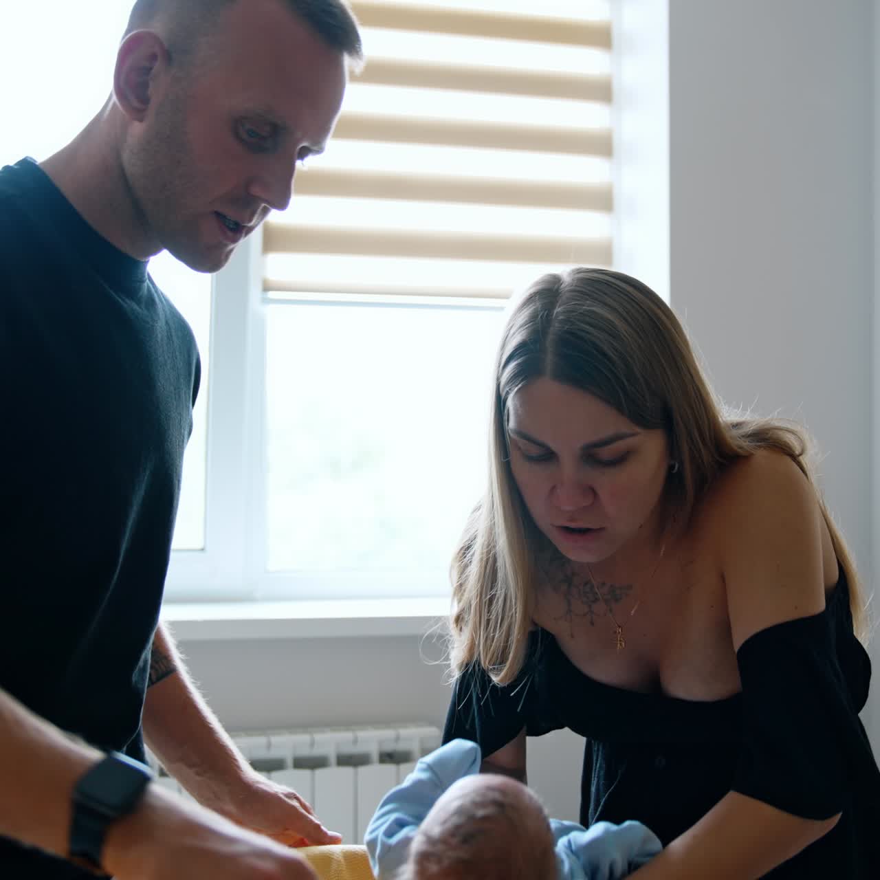 Parents taking care of their newborn baby. Mother puts her child carefully into the crib
