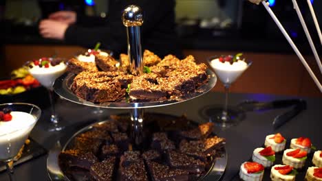 Nusskeile-Dessert-In-Einem-Buffet-In-Einem-Hotel-Oder-Bei-Einer-Veranstaltung-Mit-Anderen-Dessertpreisen-Im-Hintergrund-Auf-Dem-Dunklen-Tisch