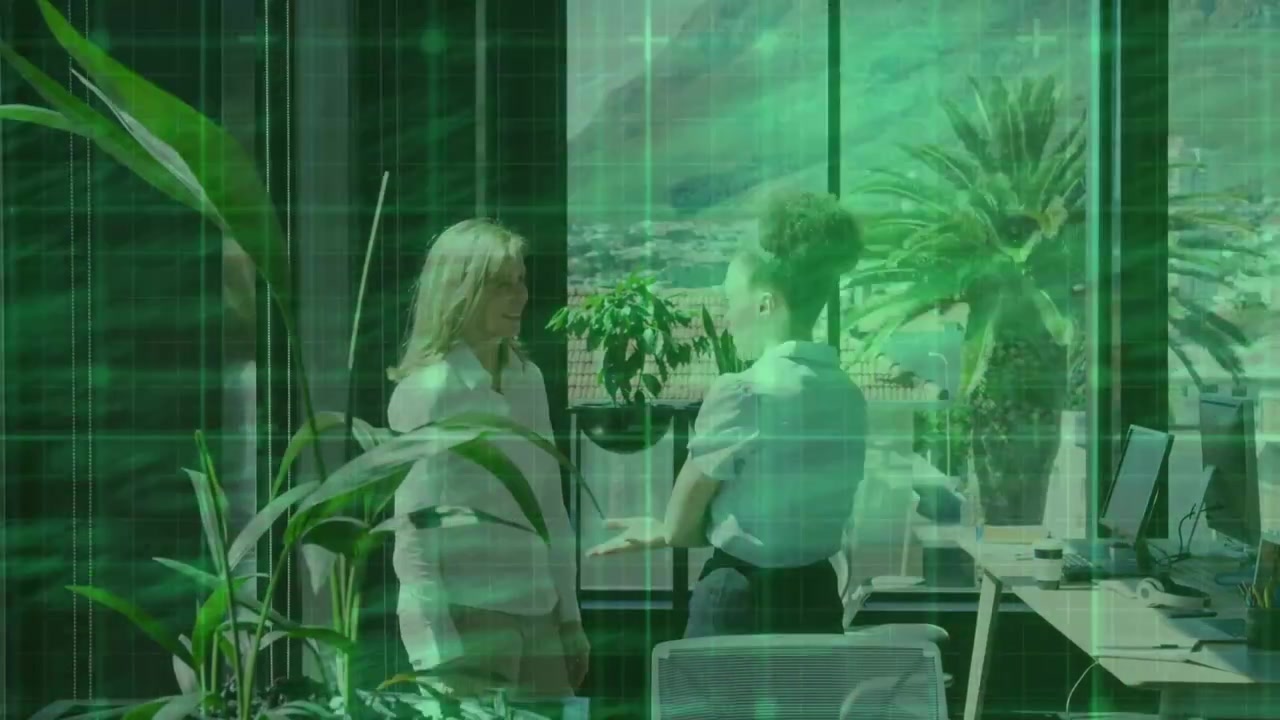 Two women in office starting project talk near window, sitting as green grid overlaying scene
