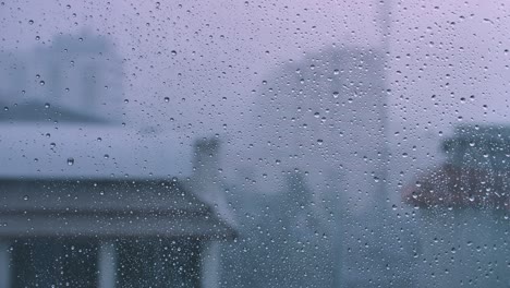 rain drops on glass window with city background.