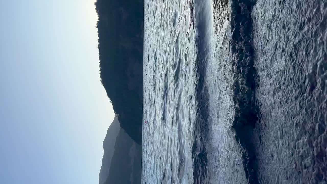 vista panorámica de un lago sereno con montañas lejanas bajo un cielo azul claro en la patagonia argentina
