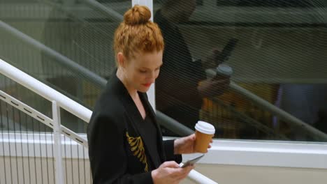 businesswoman using mobile phone while moving downstairs 4k