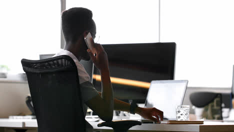 male executive using laptop while talking on mobile phone 4k