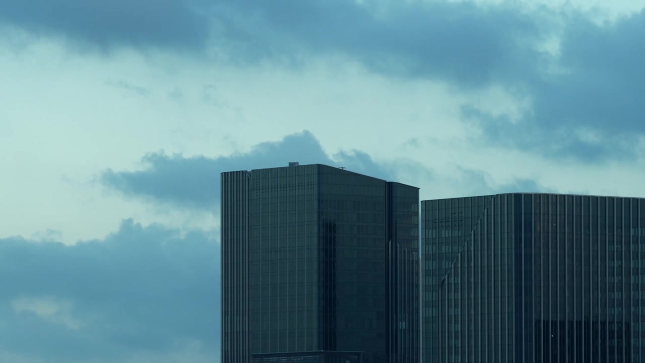 Nuvole che si muovono oltre gli edifici per uffici cinesi durante l'ora blu.