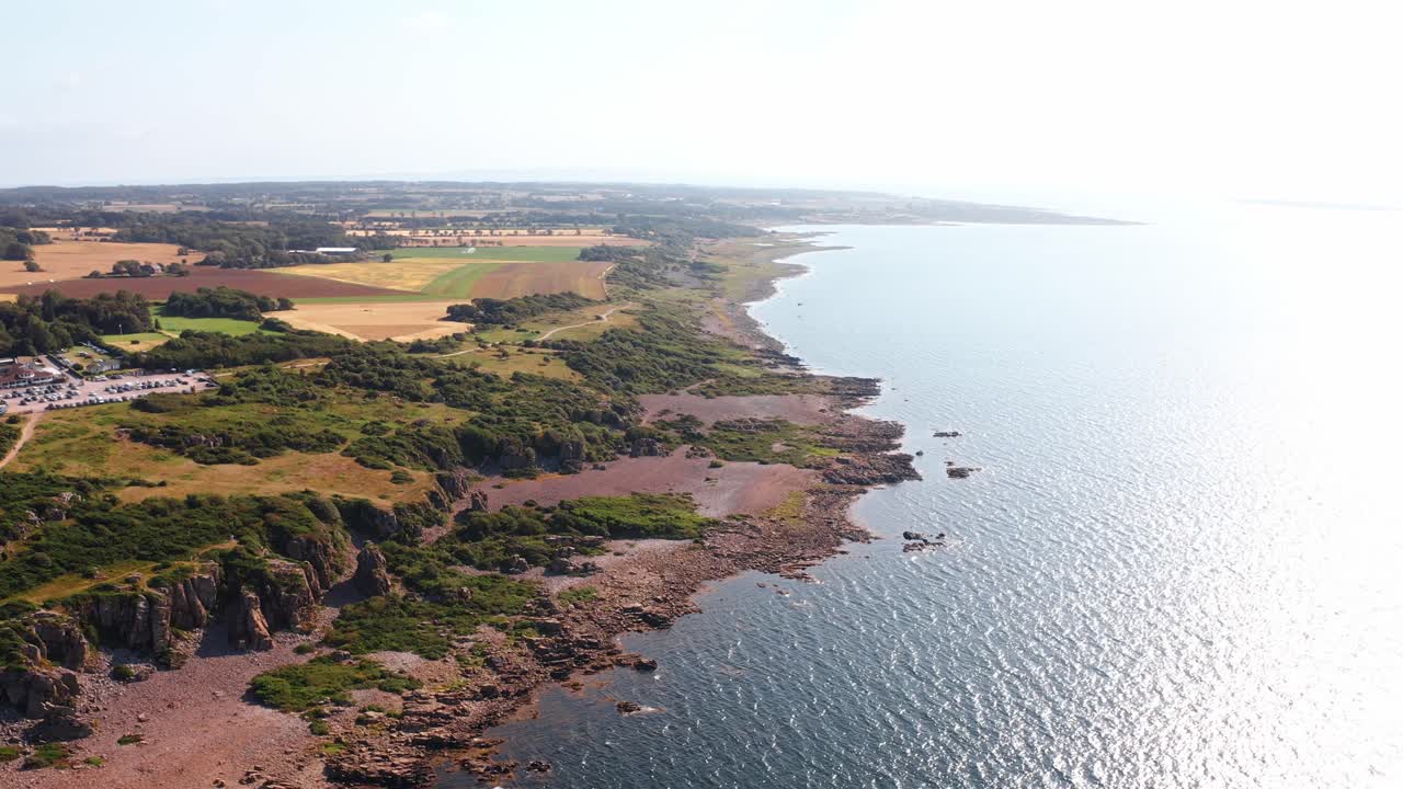 A beautiful aerial shot of a coastal landscape in Norway, showcasing rocky cliffs and tranquil waters