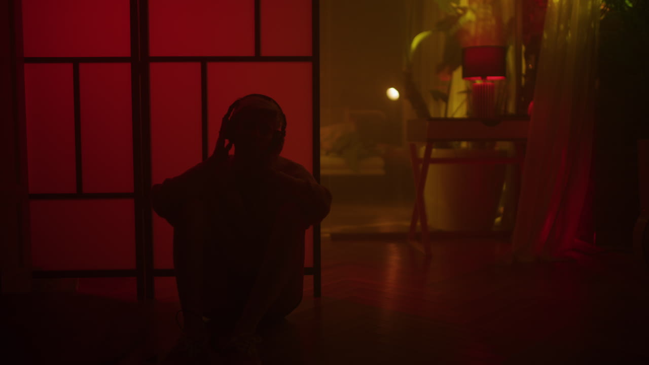 Person Sitting in a Room with Headphones on