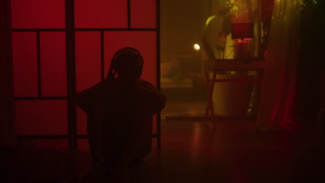 Person Sitting in a Room with Headphones on