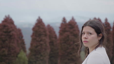 a young woman appears to be searching for her way as she observes the surroundings of the park