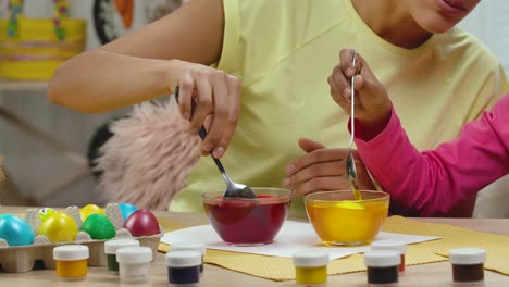 madre e hija coloreando huevos de pascua