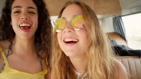 two beautiful friends happily blowing bubbles