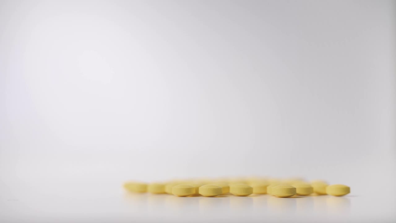 Close-up of Yellow Pills on White Background