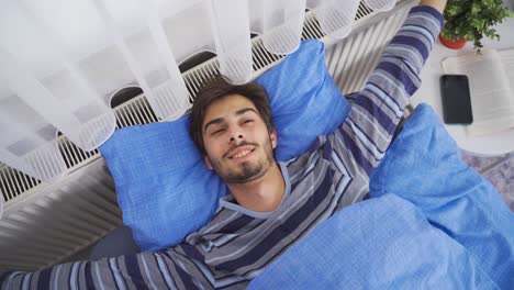 to wake up. happy young man waking up.