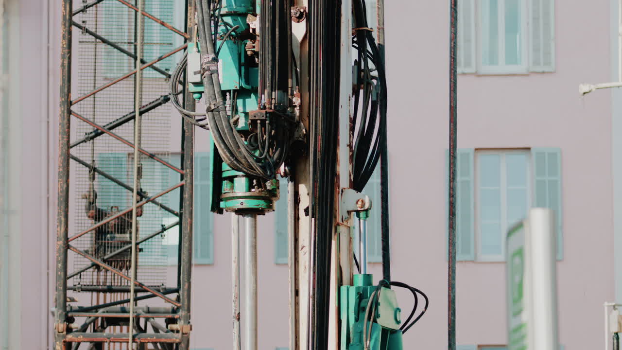 Close up of industrial drilling equipment with hydraulic cables and metal framework
