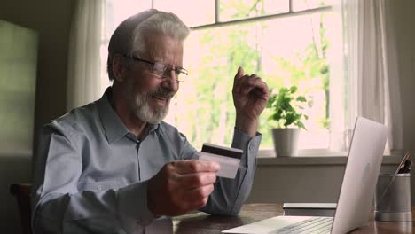 mature man use laptop enters card data makes purchase online