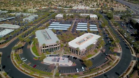 aerial pan around symmetrical office buildings among palm trees