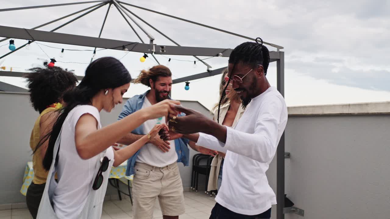Group of friends celebrating and dancing on a rooftop