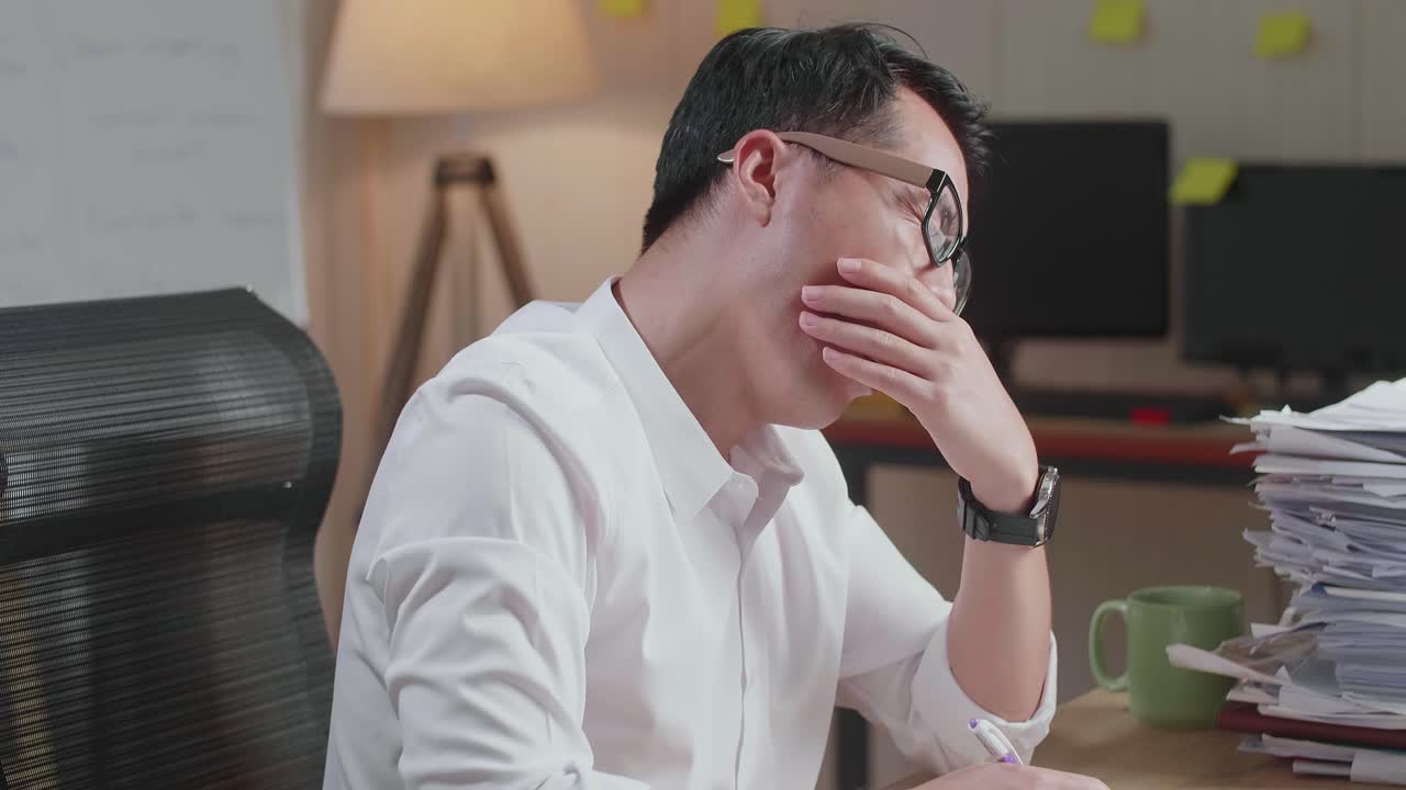 사무실에서 문서와 함께 열심히 일하는 동안 는 피곤한 아시아 남자의 근접