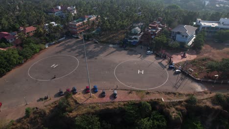 aerial drone footage of varkala helipad surrounded by buildings and trees