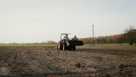 farmer using a tractor in a field for soil preparation