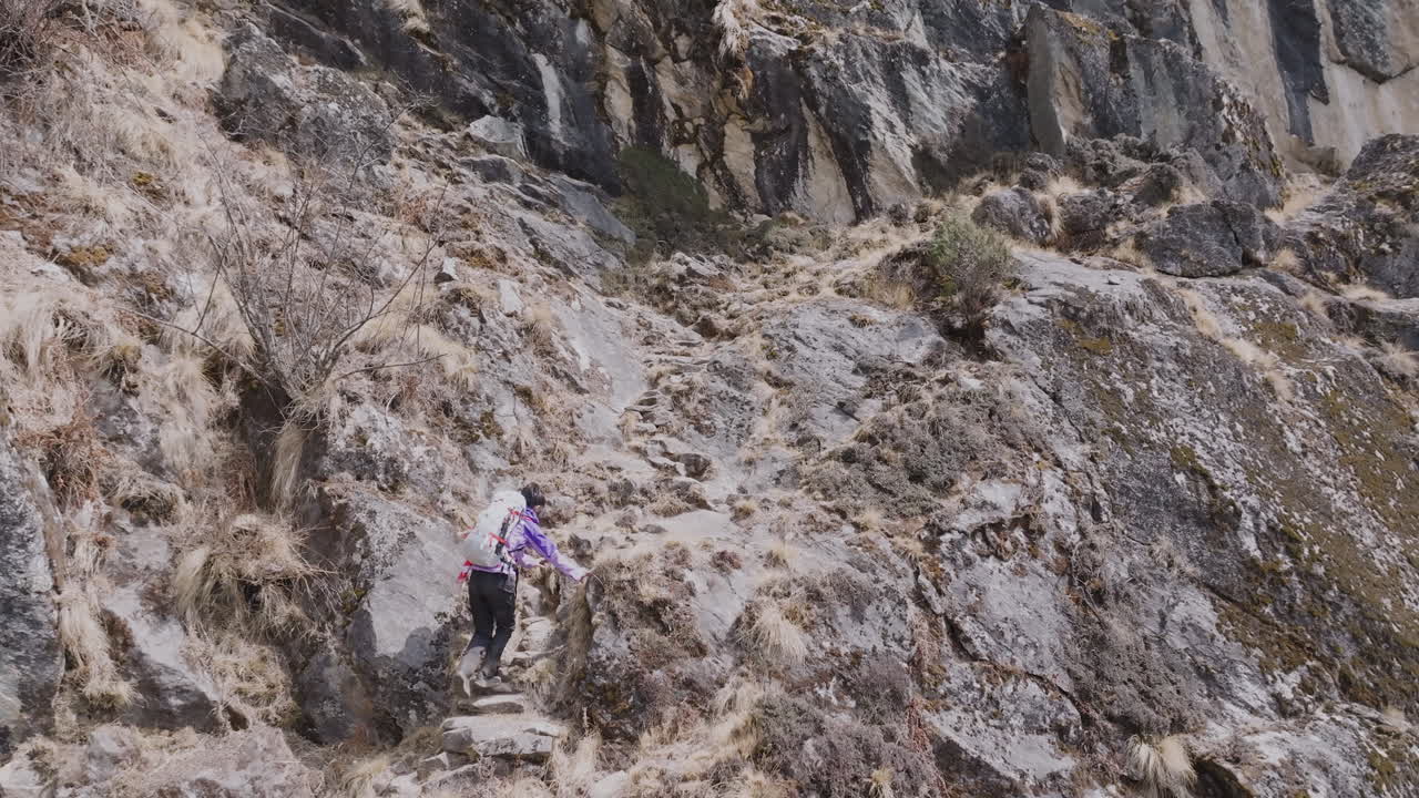 Everest Ana Kampı'na Üç Geçit rotası üzerinden yürüyüş yapan turistlerin drone çekimi. Nepal'de engebeli arazi, yüksek irtifa parkuru ve huzur hissiyle macera turizmi.