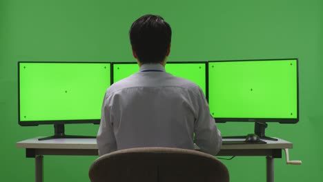 persona mirando la pantalla verde del monitor triple