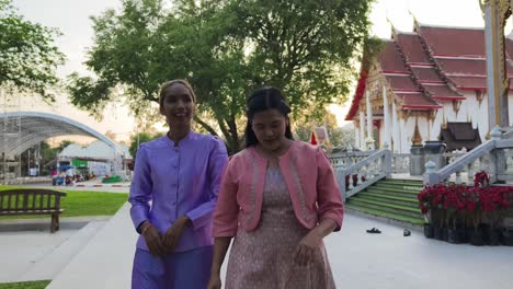 dos mujeres con ropa tradicional tailandesa en un templo