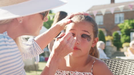 Toma-De-Cámara-Lenta-De-Niña-En-El-Puesto-De-Pintura-De-La-Cara-En-La-Fiesta-Del-Jardín-De-Verano